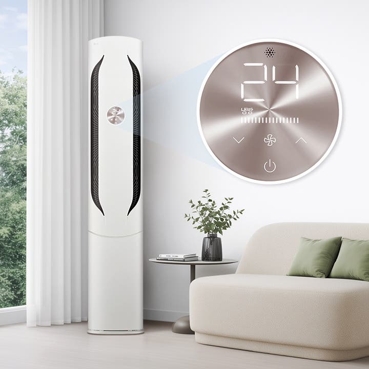 거실 창가에 에센스 화이트 색상의 LG 휘센 오브제컬렉션 위너 에어컨 1시리즈 제품이 놓여 있고 탁자와 소파가 배치되어 있습니다. 제품의 디스플레이를 통해 24도, 냉방 모드로 작동 중인 것을 확인할 수 있습니다.