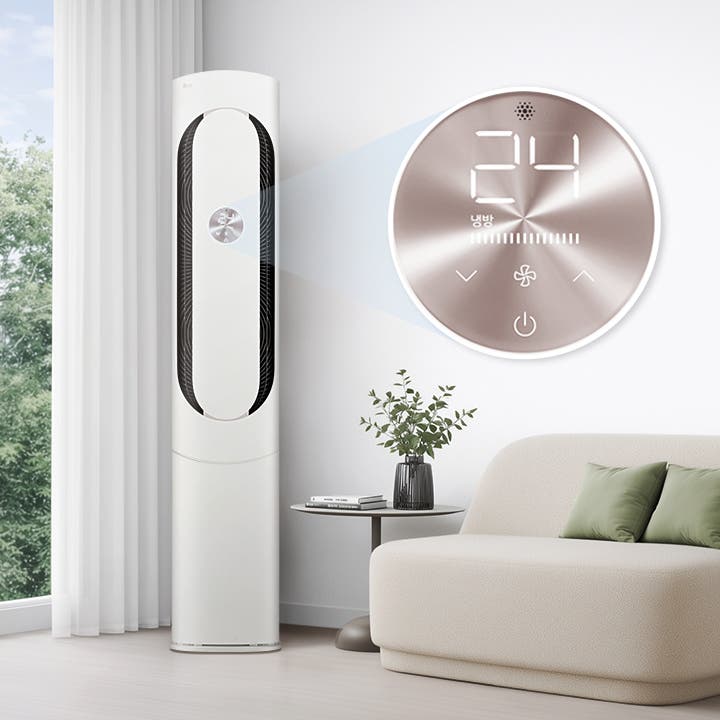 거실 창가에 에센스 화이트 색상의 LG 휘센 오브제컬렉션 칸 에어컨 1시리즈 제품이 놓여 있고 탁자와 소파가 배치되어 있습니다. 제품의 디스플레이를 통해 24도, 냉방 모드로 작동 중인 것을 확인할 수 있습니다.