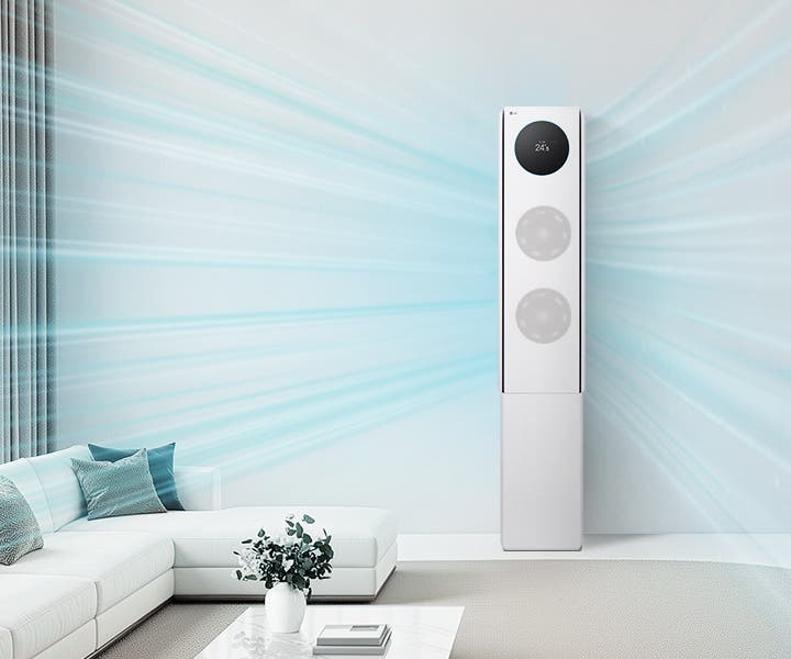 LG 휘센 AI 오브제컬렉션 뷰I 프로 에어컨이 거실 벽면 앞에 설치되어 있으며, 상단의 원형 디지털 디스플레이에 온도 정보가 표시되어 있습니다. 에어컨 전면에는 3개의 팬이 보여지고 있고, 전면과 측면에서 연한 파란색 선 형태의 그래픽이 사방으로 퍼져 나가며 실내 전체로 기류가 확산되는 모습을 나타내고 있습니다. 거실에는 큰 창문을 통해 자연광이 들어오고, 왼쪽에는 밝은 색의 L자형 소파와 쿠션이 배치되어 있으며, 중앙에는 작은 테이블과 화분이 놓여 있습니다. 이 이미지는 3개의 팬이 돌면서 에어컨 양쪽 토출구를 통해 강력한 바람이 나오는 실내 공간을 시각적으로 표현하고 있습니다.
