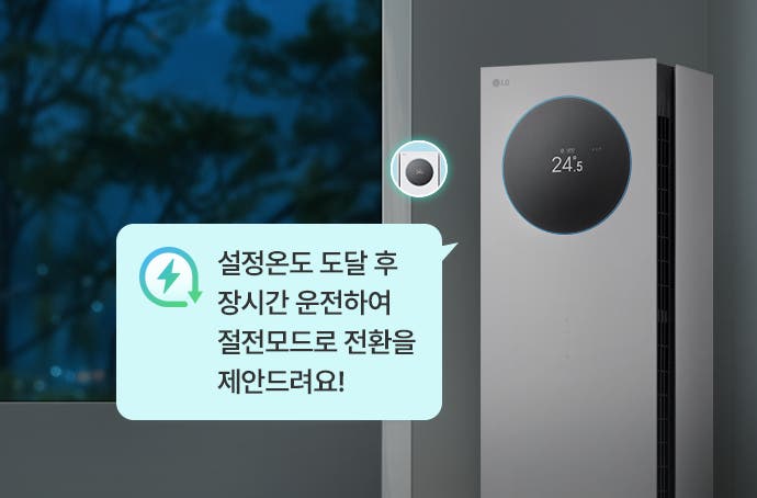 LG 휘센 AI 오브제컬렉션 뷰I 프로 에어컨이 오른쪽에 서 있으며, 전면의 원형 디스플레이에는 온도 24.5°가 표시되어 있습니다. 화면 왼쪽에는 창문을 통해 어두운 밤의 풍경이 보이며, 나무와 불빛이 희미하게 드러납니다. 에어컨 옆에는 녹색 번개 모양과 화살표가 결합된 절전 아이콘과 함께 작은 원형 디스플레이가 확대되어 있으며, 그 아래에는 말풍선 안에 설정온도 도달 후 장시간 운전하여 절전모드로 전환을 제안드려요!라는 문구가 포함되어 있습니다.