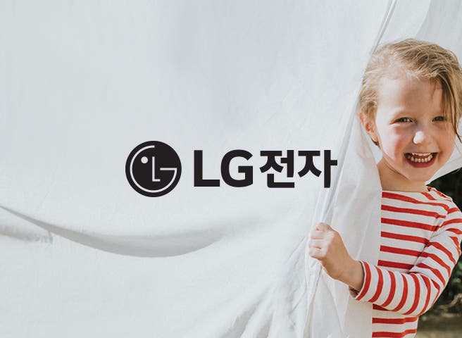 빨간색과 흰색 줄무늬 셔츠를 입은 어린아이가 하얀 천을 잡고 웃고 있는 모습이 보입니다. 검은색 LG로고와 검은색 글씨로 LG전자라는 텍스트가 적혀 있습니다.