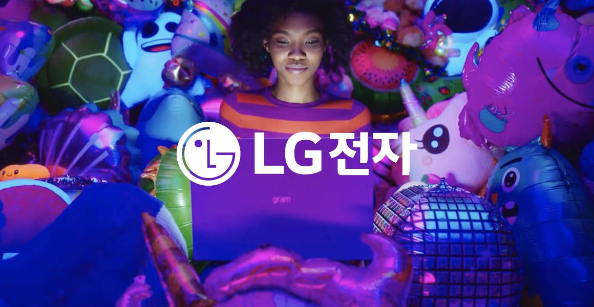 gram 노트북을 들고 있는 사람이 보이며, 주변에는 유니콘, 거북이, 귀여운 얼굴 모양의 풍선들이 가득 차 있습니다. 흰색 LG로고와 흰색 글씨로 LG전자라는 텍스트가 적혀 있습니다.