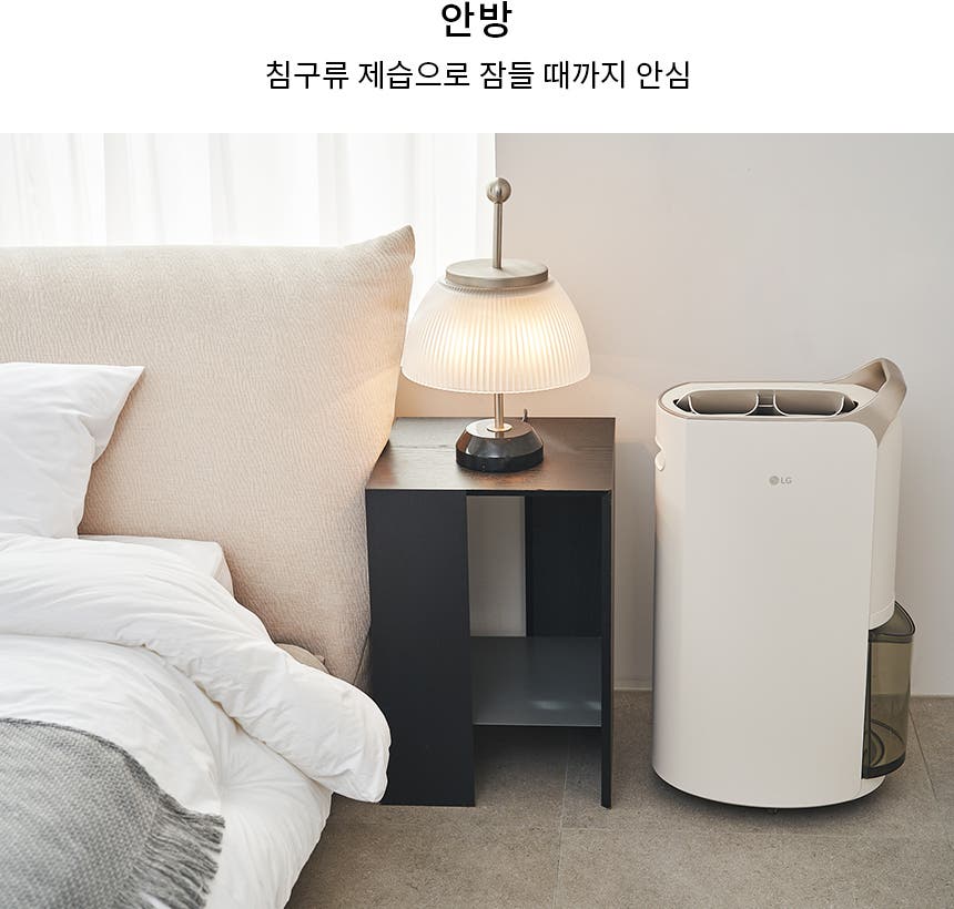 침대와 베개가 있는 침실의 모습입니다. 침대 옆에는 작은 테이블과 램프가 놓여 있으며, 그 옆에는 LG 로고가 있는 제습기가 있습니다. 텍스트로는 안방 침구류 제습으로 잠들 때까지 안심이라고 적혀 있습니다.