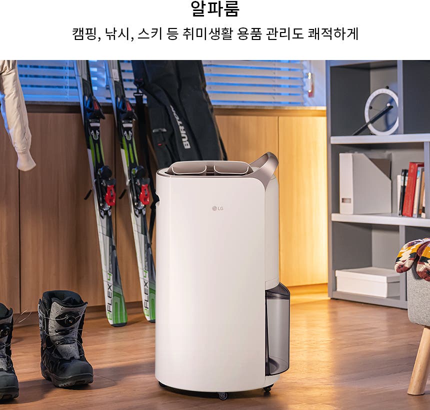 알파룸이라는 제목 아래 캠핑, 낚시, 스키 등 취미생활 용품 관리도 쾌적하게라는 문구가 있습니다. 실내 공간에 옷걸이에 걸린 재킷과 바닥에 놓인 부츠, 스키 장비가 보입니다. LG 로고가 있는 가전 제품이 놓여 있으며, 책장에는 여러 권의 책과 장식품이 진열되어 있습니다. 스노보드와 모자, 장갑이 있는 의자가 있습니다.