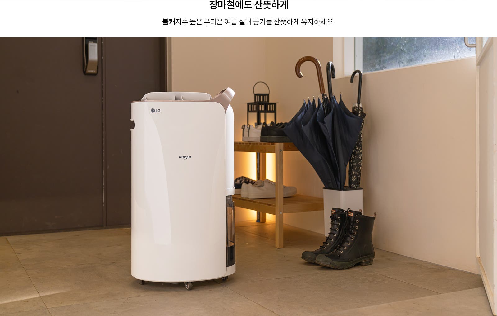 LG 휘센 제습기가 실내에 놓여 있으며, 그 옆에는 여러 개의 우산이 꽂혀 있는 우산꽂이와 신발이 놓인 선반이 있습니다. 바닥에는 검은색 부츠가 있습니다. 상단에는 장마철에도 산뜻하게라는 문구와 불쾌지수 높은 무더운 여름 실내 공기를 산뜻하게 유지하세요.라는 문장이 적혀 있습니다.