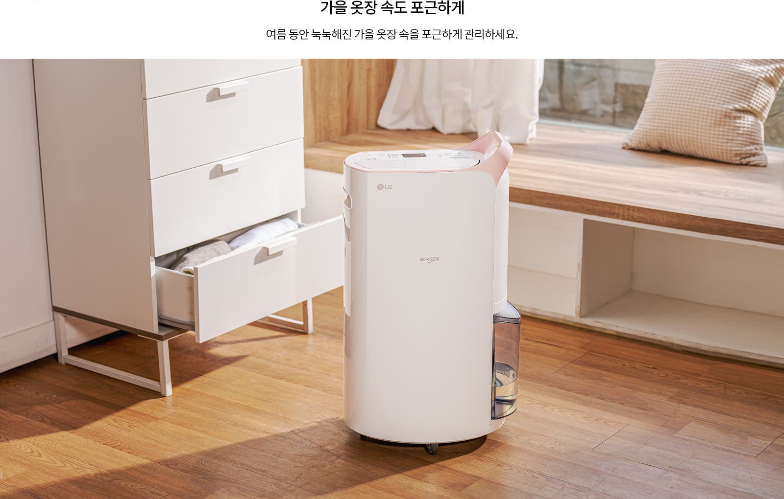가을 옷장 속도 포근하게. 여름 동안 눅눅해진 가을 옷장 속을 포근하게 관리하세요. 하얀 서랍장과 LG 휘센 제습기가 나무 바닥 위에 놓여 있으며, 서랍은 열려 있고 안에 옷이 보입니다. 창가에는 베개가 놓여 있습니다.