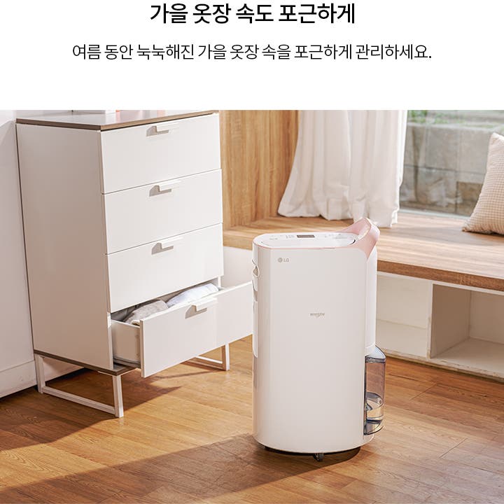 가을 옷장 속도 포근하게. 여름 동안 눅눅해진 가을 옷장 속을 포근하게 관리하세요. 하얀 서랍장과 LG 휘센 제습기가 나무 바닥 위에 놓여 있으며, 서랍은 열려 있고 안에 옷이 보입니다. 창가에는 베개가 놓여 있습니다.