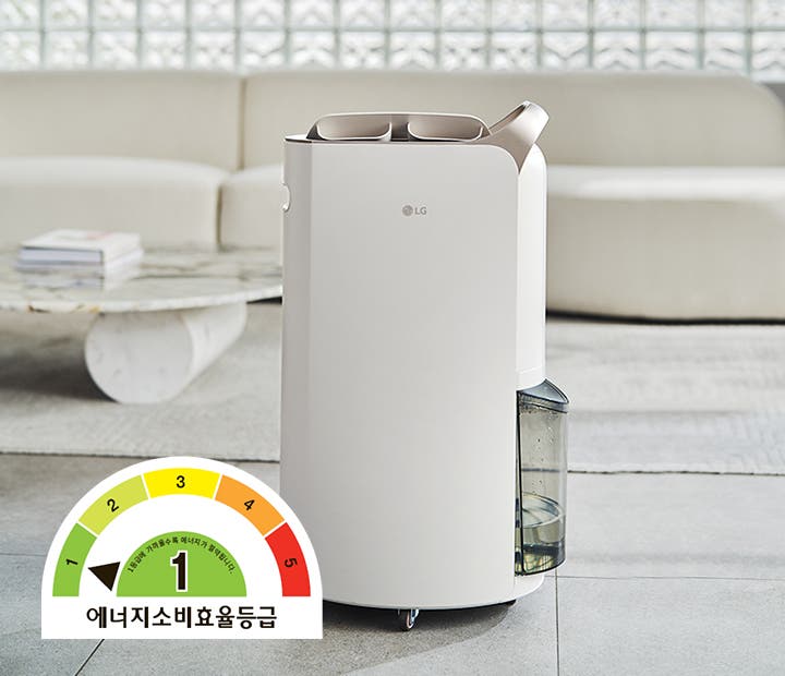 LG 휘센 제습기가 거실 한가운데에 놓여 있습니다. 에너지소비효율 1등급 표시가 보입니다.