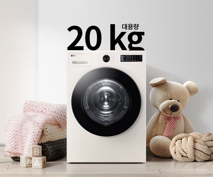 세탁기가 놓여 있으며, 20kg 대용량이라는 텍스트가 있습니다. 세탁기 주변에는 분홍색 담요와 곰 인형이 있고, 바닥에는 알파벳 블록이 놓여 있습니다. 배경은 밝은 색상의 벽과 그림이 걸려 있습니다.