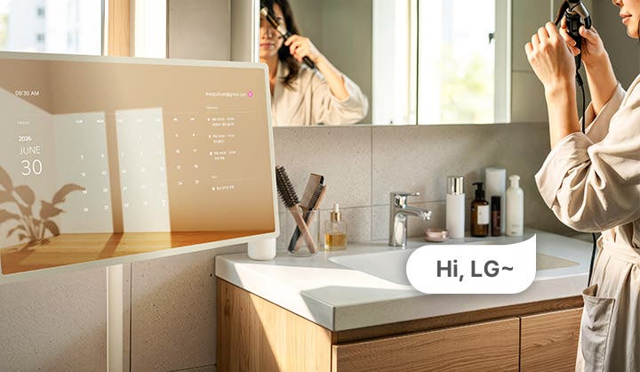 스탠바이미를 보며 머리를 정돈하는 여성의 모습이 보이는 이미지입니다. hi, LG 라고 말하여 음성인식이 됨을 보여줍니다.