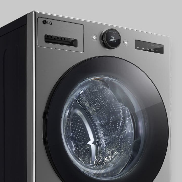 LG 로고가 있는 세련된 디자인의 세탁기입니다. 원형의 투명한 문이 있으며, 디지털 디스플레이와 조작 버튼이 있습니다. 금속성의 외관이 현대적이고 깔끔한 느낌을 줍니다.