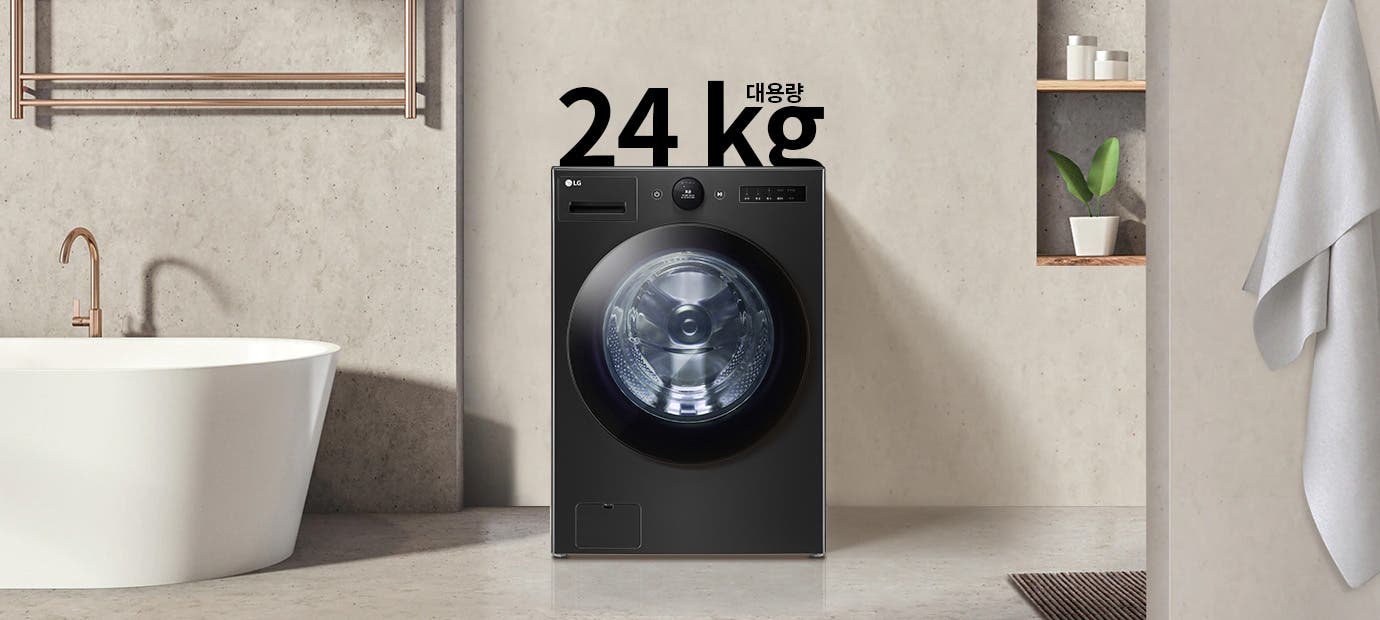 세탁기가 욕실에 놓여 있으며, 세탁기 위에 24 kg 대용량이라는 글자가 있습니다. 욕실에는 욕조와 수건이 걸려 있고, 벽 선반에는 화분과 용기가 놓여 있습니다.