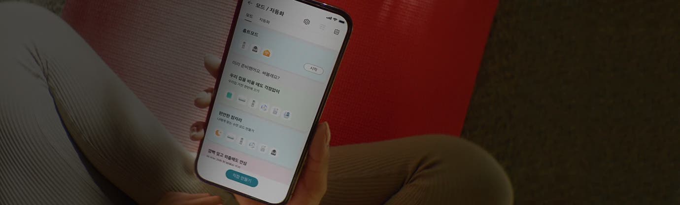 스마트폰 화면에 홈 모드와 관련된 설정 화면이 표시되어 있습니다. 화면 상단에는 모드 / 자동화라는 제목이 있으며, 그 아래에 홈 모드가 선택되어 있습니다. 미리 준비했어요. 써볼래요?라는 문구와 함께 시작 버튼이 보입니다. 그 아래에는 우리 집을 비울 때도 걱정없이 우리집 가전 한번에 끄기라는 문구와 함께 여러 아이콘이 나열되어 있습니다. 편안한 잠자리 나에게 맞는 수면 모드 만들기라는 문구와 함께 여러 아이콘이 나열되어 있습니다. 깜빡 잊고 외출해도 안심이라는 항목이 보입니다. 화면 하단에는 직접 만들기라는 버튼이 있습니다.