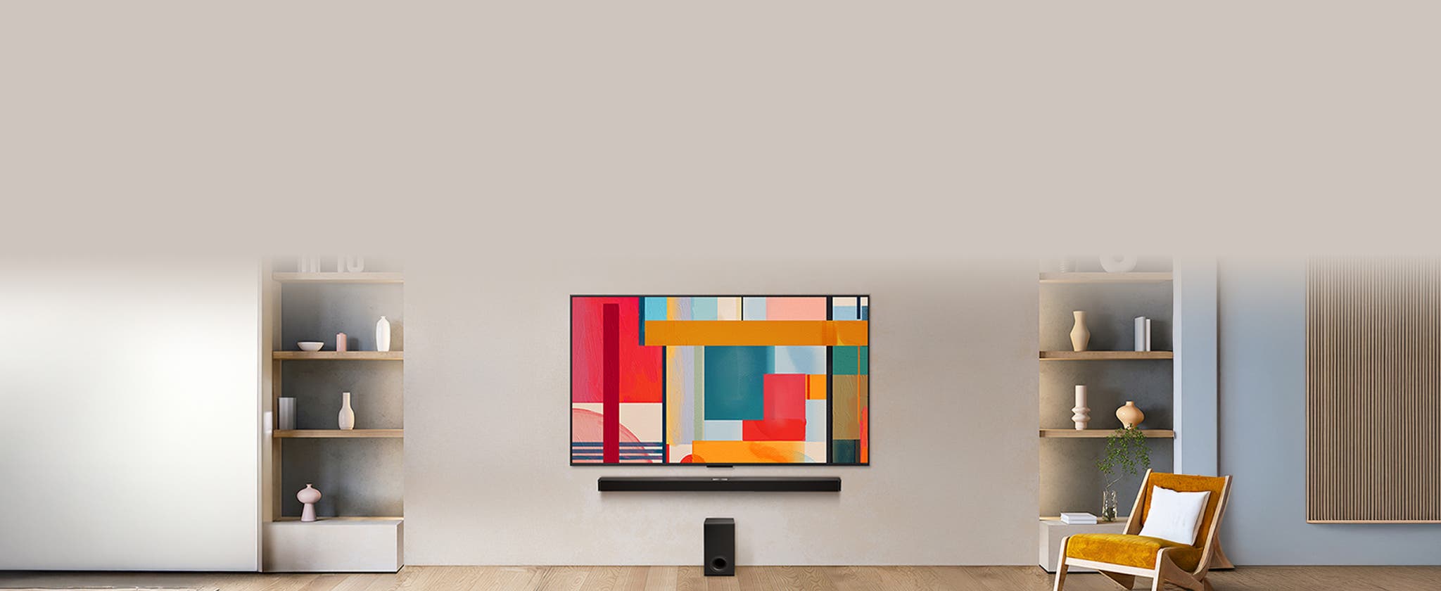 따뜻한 거실 공간 중앙에 대형 TV와 사운드바, 우퍼가 배치되어 있으며, 양쪽 선반과 포인트 체어가 더해져 모던하고 아늑한 분위기를 연출하는 모습입니다.