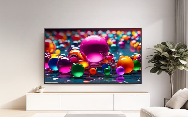밝은 거실에 TV가 놓여 있고, 화면에는 다채로운 색상의 구 모양 오브제들이 선명하게 표현되어 공간에 생동감과 화려한 분위기를 더합니다.