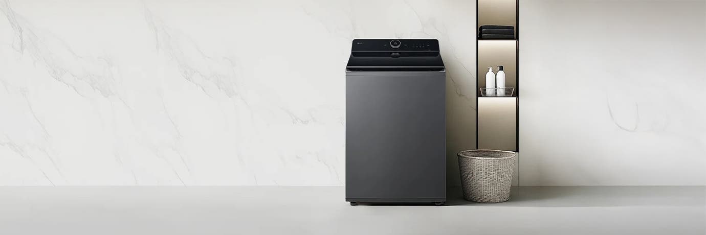 아이보리색 LG 세탁기가 밝은 배경 앞에 놓여 있으며, 옆에는 밝은색 선반이 놓여 있습니다.