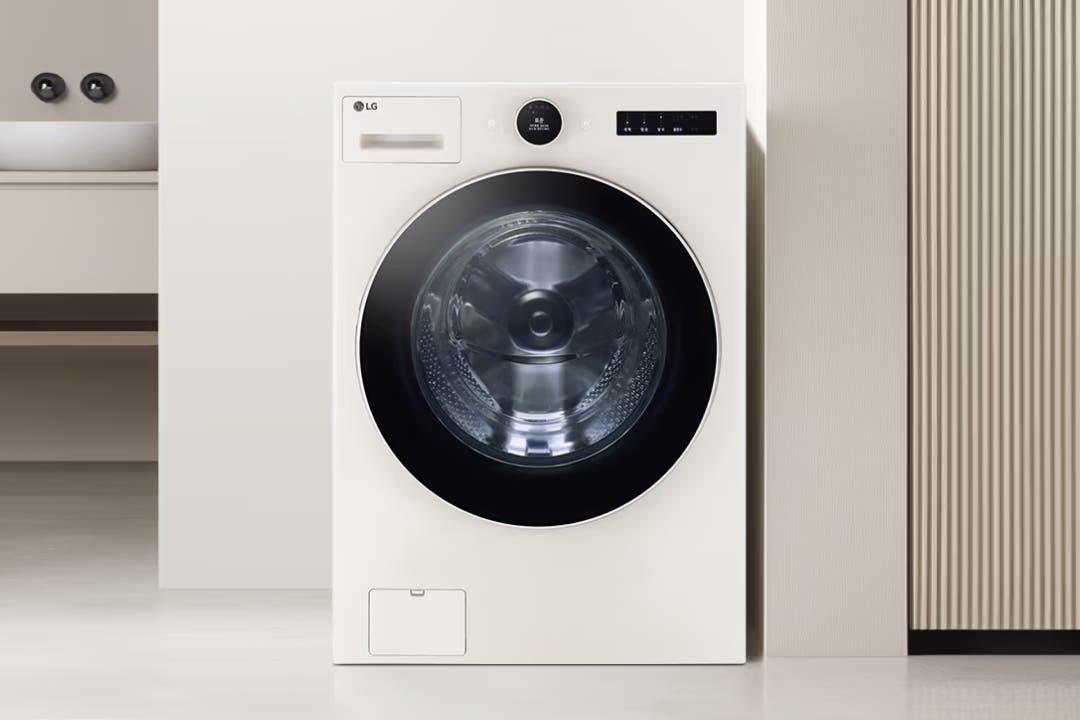 아이보리색 LG 세탁기의 전면 모습으로, 옆에는 같은 톤의 세면대와 세로 줄무늬 패턴의 벽면이 보입니다.