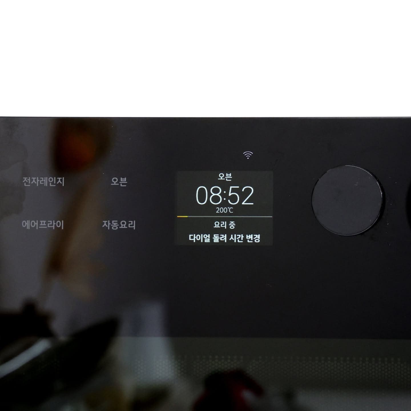 광파오븐 조작부를 확대한 것. 디스플레이에 오븐 조리 중이라는 것이 표시되어 있다.