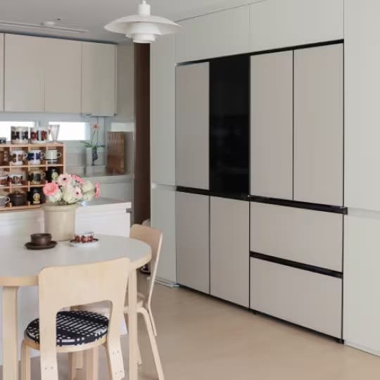 LG 냉장고 실제 설치 예시, 베이지 톤의 주방장과 조화를 이루는 Fit & Max 냉장고, 옆에 화병에 담긴 꽃이 장식된 공간