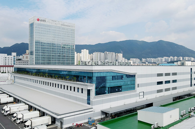 산과 도심을 배경으로 한 대규모 공장 단지 형태의 LG전자 창원 스마트파크 건물 전경이 보이는 모습