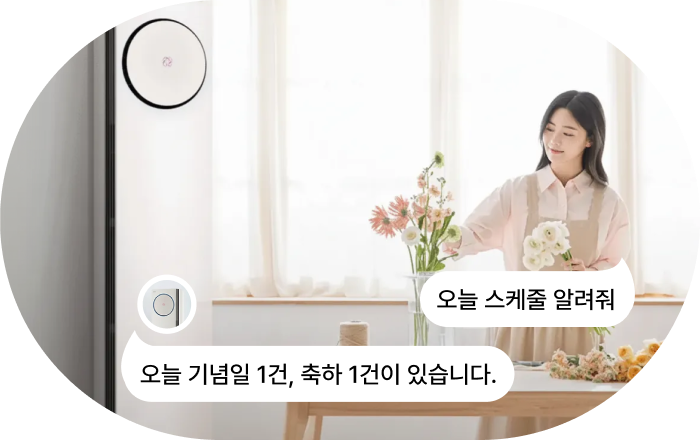 LG 에어컨 AI 음성 명령 기능 이미지입니다. 여성이 꽃을 정리하는 모습과 함께 LG 에어컨 AI 음성 명령과 응답 말풍선이 표시됩니다. 명령: '오늘 스케줄 알려줘' 응답: '오늘 기념일 1건, 축하 1건이 있습니다.'