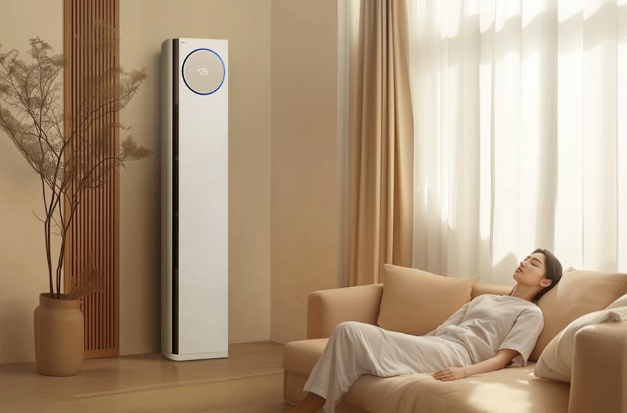 LG 휘센 타워 에어컨 앞 소파에 앉아 시원한 바람을 쐬며 휴식을 취하는 사람. 편안한 자세로 리모컨을 조작하고 있습니다.